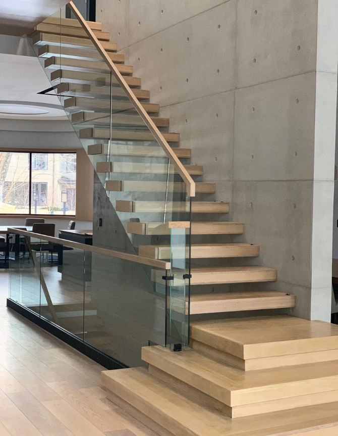 Chicago floating stairs with wood handrails and standoff glass.